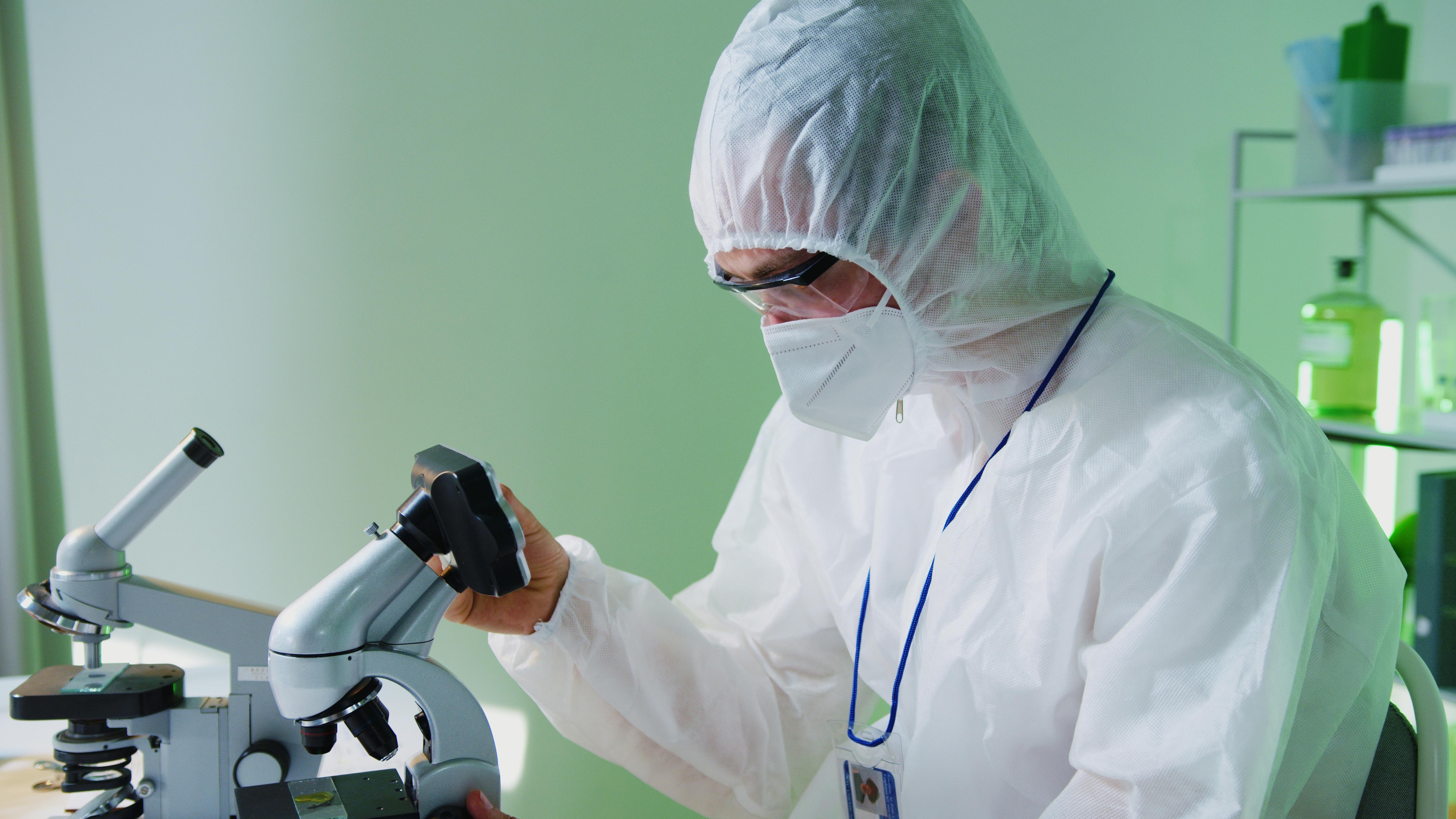 Scientist in lab coat at microscope