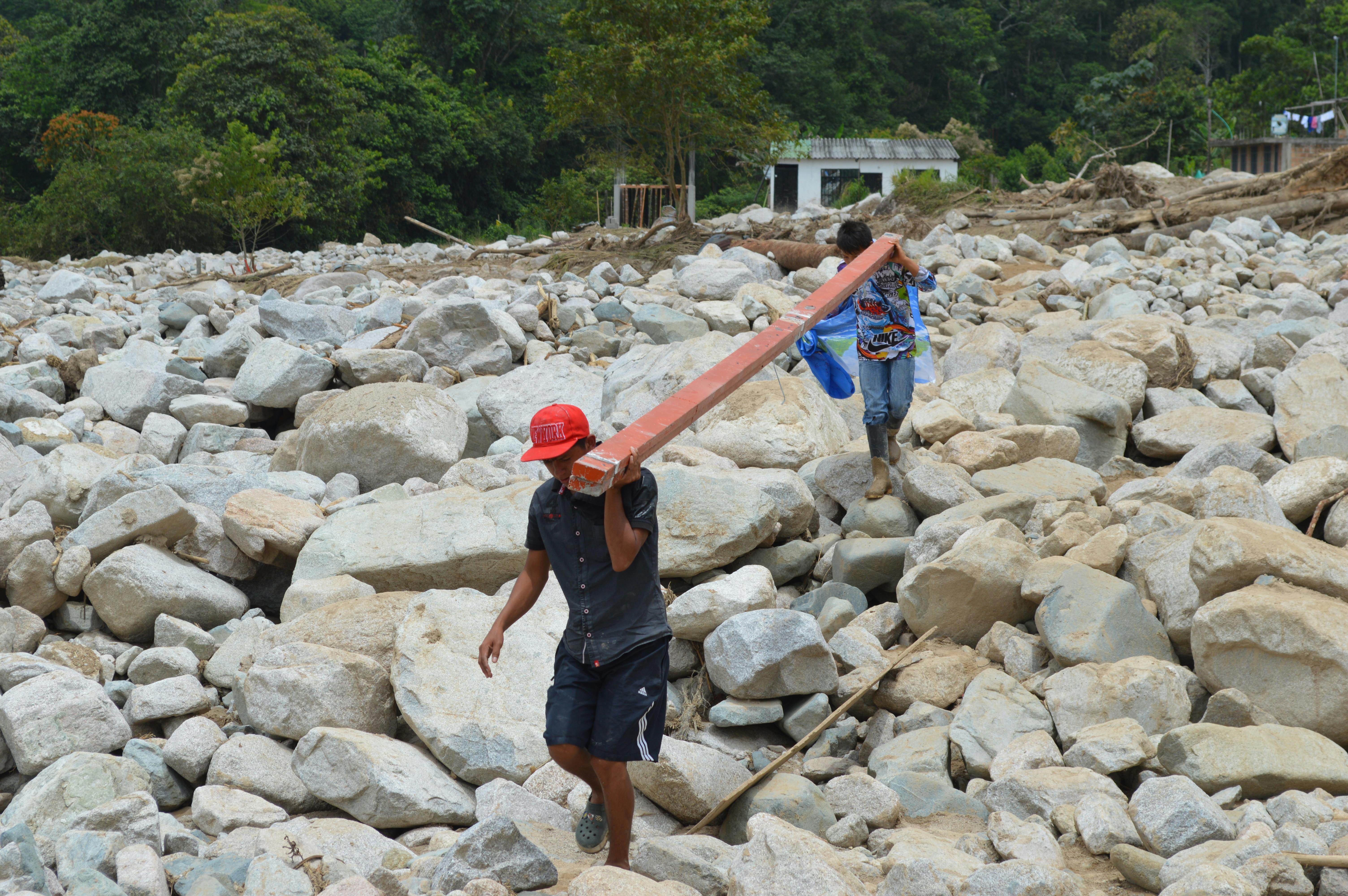 Workers carrying materials on rocky terrain